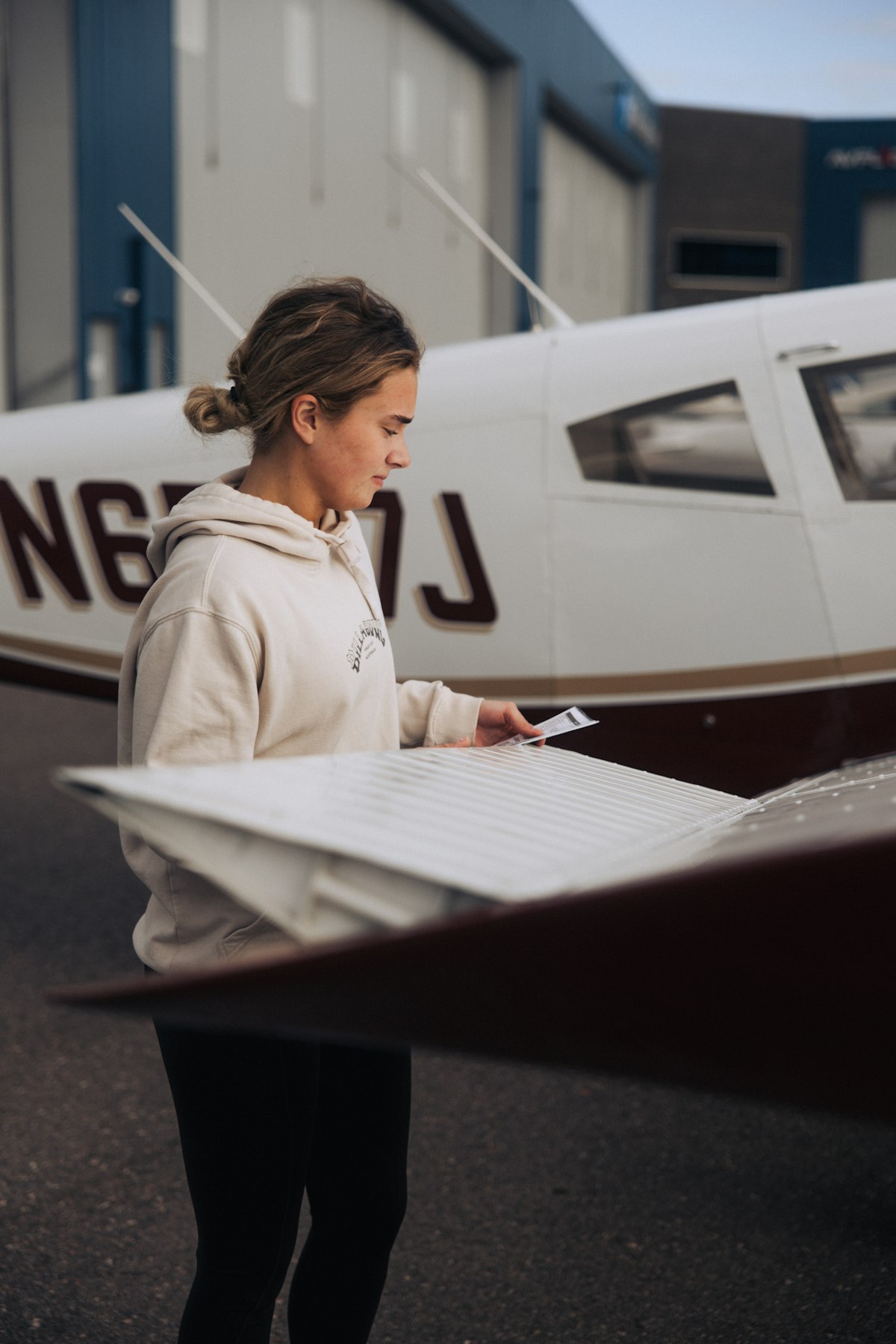 A student pilot preparing for a discovery flight beside a training aircraft
