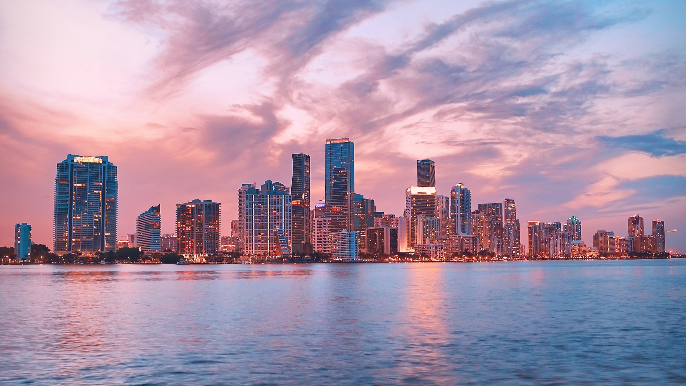 The downtown Miami skyline over Biscayne Bay at twilight, pink and blue sky