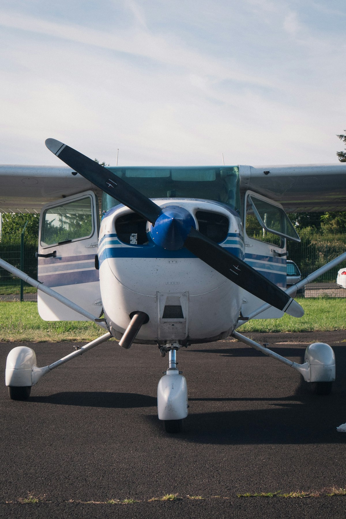 A white and blue single-engine Cessna training aircraft
